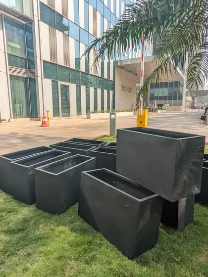 A collection of the unboxed black FRP planters ready for the next phase. Their matte finish provides a sophisticated and modern look that complements the building's architecture.