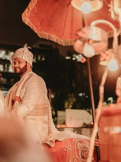 The groom's grand entrance on a horse, captured with an artistic flair through foreground lights.