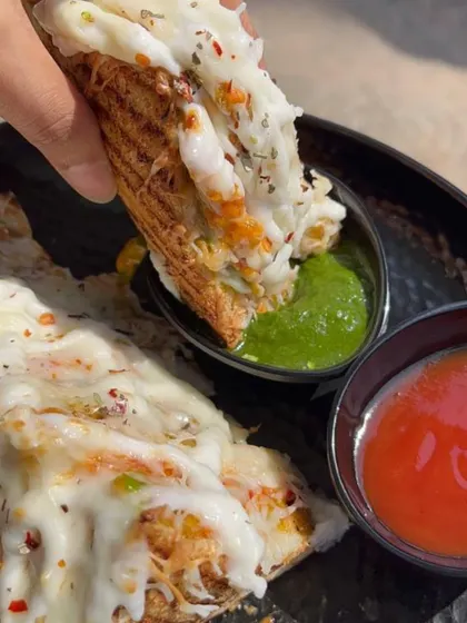A cheesy bite of my grilled sandwich, dipped in spicy green chutney. The combination of melted cheese and tangy chutney is simply irresistible.