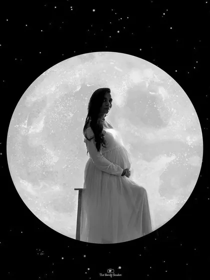 A creative and artistic silhouette of a pregnant woman against a full moon. This black and white composite image is a beautiful example of the unique, edited art pieces we can create.
