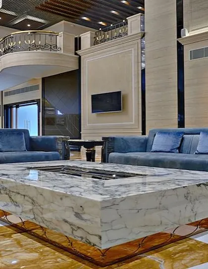We designed bespoke furniture for the A-Class Marble showroom, including this massive center table crafted from a single block of marble. This piece serves as a powerful statement of the brand's product and our ability to integrate it into functional, luxurious design.