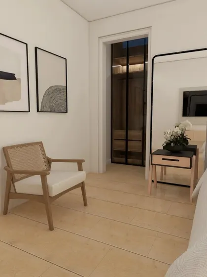 A serene Scandinavian bedroom design. The simple cane armchair, minimalist art, and light wood flooring create a tranquil retreat that feels both timeless and modern.