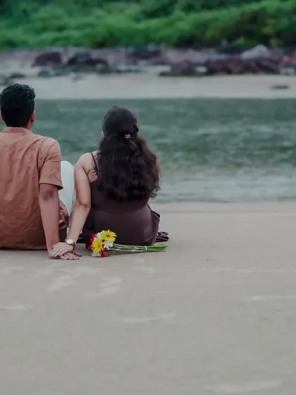 The couple sits on the sand, looking out at the water together. This quiet, serene photo from their Kokan pre-wedding shoot is a beautiful depiction of shared peace.