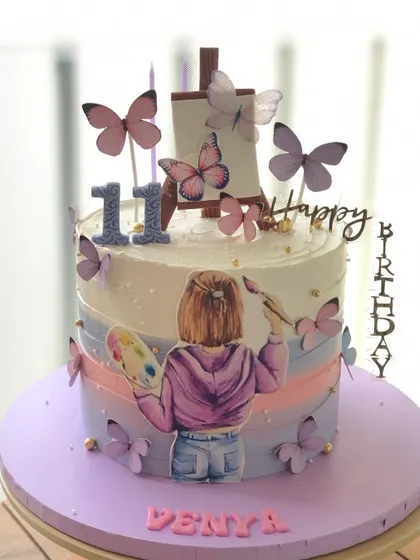 A cake for a young artist, with a painter girl illustration and a purple ombre and butterfly theme.