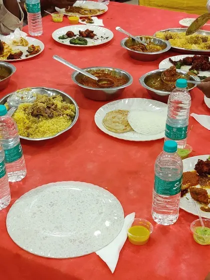 The meal in progress. Guests are seen enjoying our chicken biryani, parathas, and curries, showing the hearty and satisfying nature of our food.