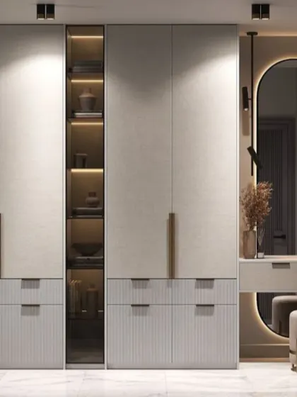 I create storage solutions that are both beautiful and practical. This custom wardrobe integrates a full dressing unit with a backlit mirror, combining drawers and cabinets with a display section for a complete personal vanity area.