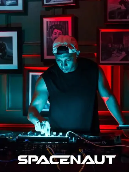 A DJ in his element during the Spacenaut takeover, with the signature gallery wall as a backdrop.