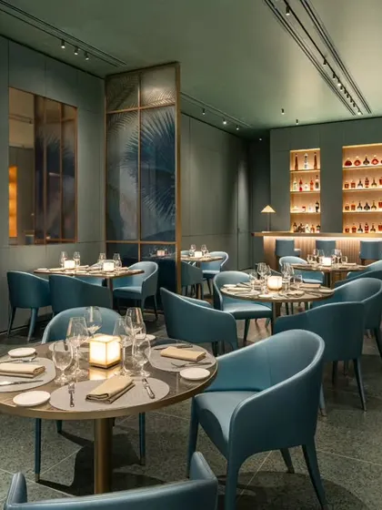 A wider perspective of the Armani Caffe dining room, showcasing the impressive wine storage unit. This shot is designed to communicate the breadth of the restaurant's offerings and the thoughtful layout of the space, from the bar to the seating arrangements.