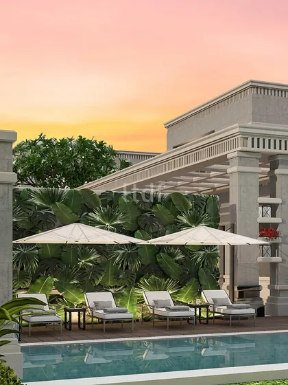 The verdant greenery enveloping this pool area creates a serene backdrop against the shimmering water. This harmonious fusion of a classical architectural theme and natural elements elevates the poolside experience into a truly lavish retreat.