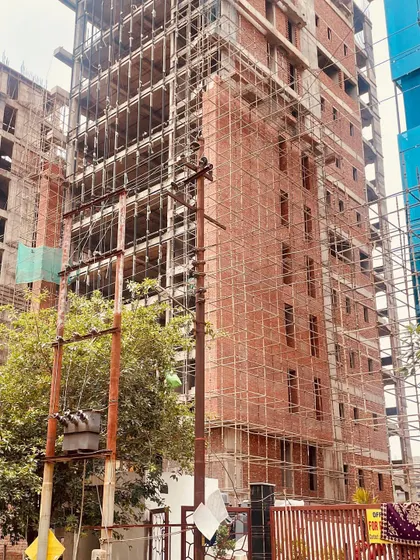 A site visit photo of an office building under construction. The exposed brickwork is clearly visible, showcasing the raw beauty and texture of the material before the final glass and finishing elements are installed.