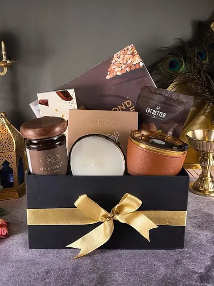 The "Royal Dazzle" hamper is all about luxury. This black and gold themed box is filled with premium snacks, a leather-wrapped tumbler, and a scented candle.