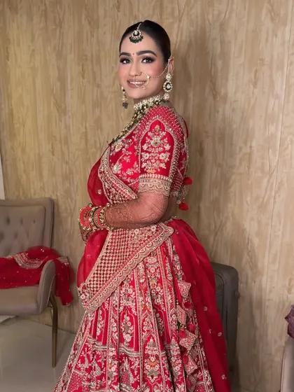 A full-length portrait of my bride Kanika. The classic red lehenga is paired with makeup that is both traditional and fresh, ensuring she looks timeless.