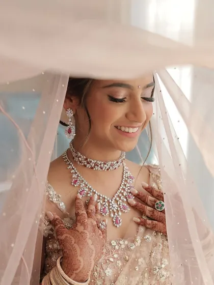 A beautiful bride captured in a moment of joy. The soft pink tones in her makeup and the delicate veil create a romantic and ethereal look that is simply unforgettable.