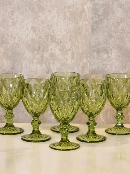 These green glass goblets have a beautiful diamond-cut texture that catches the light. They are perfect for serving water, wine, or any festive drink.