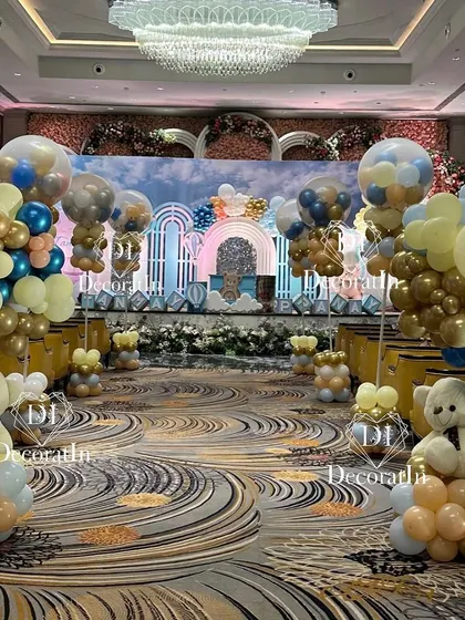 A breathtaking view of the grand event hall, with a pathway lined with teddy bear and balloon centerpieces leading to the main stage.
