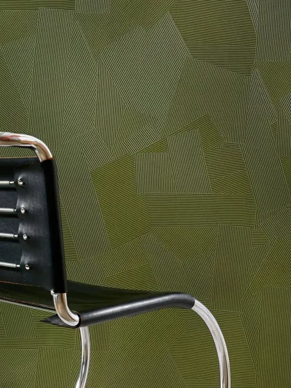 The 'Dédales' wallcovering in a deep olive green. The fine, combed lines form a complex geometric pattern that adds depth and character to the wall, making it a feature in itself.