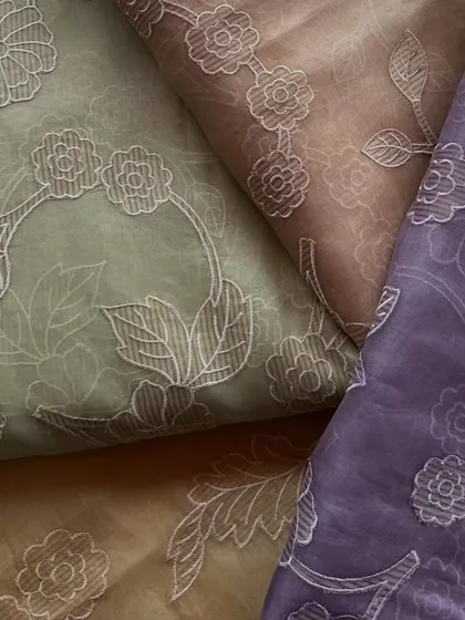 Our embroidered organza is available in a variety of earthy and pastel tones, all featuring the same elegant floral embroidery.