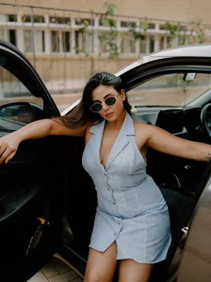 A stylish portrait of a model in a car. The composition, looking through the open door, creates an interesting and dynamic fashion shot.