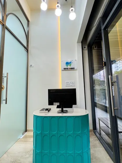 The compact and stylish reception desk at the clinic's entrance. The patterned teal paneling adds a pop of color and texture, making a memorable first impression on visiting patients.
