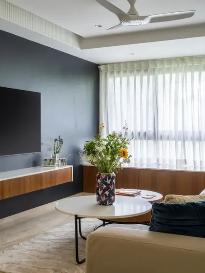 The floating media console keeps the floor clear, enhancing the sense of space. The dark wall behind the TV helps it blend in when not in use, reducing visual clutter.