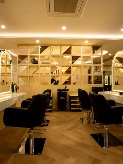 The styling stations are the heart of the salon. Here, we focused on creating a sense of personal luxury with individual backlit mirrors, comfortable hydraulic chairs, and a striking geometric feature wall that adds texture and depth.