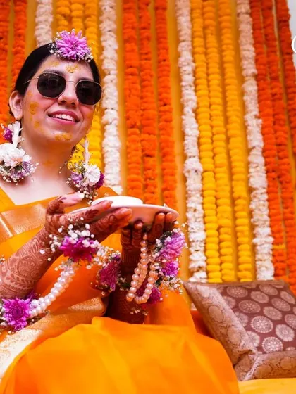 The bride, cool and composed during her Haldi ceremony. The sunglasses add a fun, modern twist to the traditional ritual.