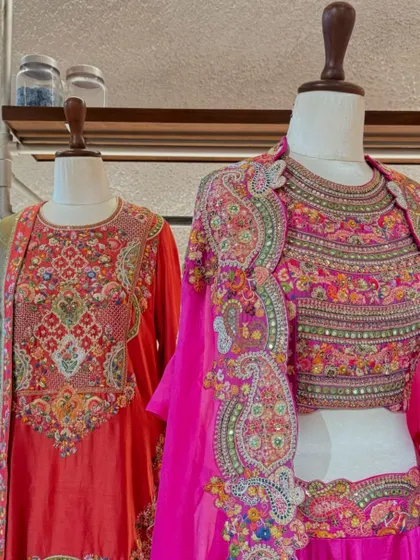 A display of heavily embroidered festive wear from Petticoat Lane, featuring a stunning pink lehenga with a multi-colored jacket.