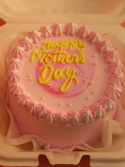 A close-up of one of our pink Mother's Day bento cakes, featuring delicate piping work and a "Happy Mother's Day" message in yellow.