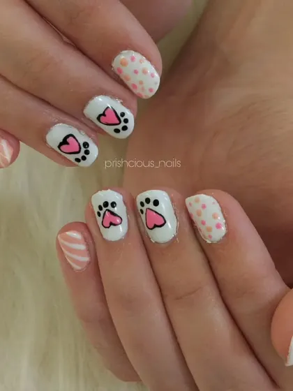 How cute are these cat paw nails? This adorable hand-painted design features little pink and black paw prints on a white base.