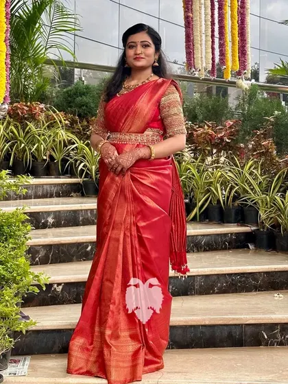 A bride looking magical in her red raw silk blouse with gold zari, a perfect example of where tradition meets glam.