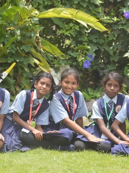 A group of girls sitting on the grass, enjoying the natural surroundings after their workshop. My space offers a safe and green area for kids to relax.