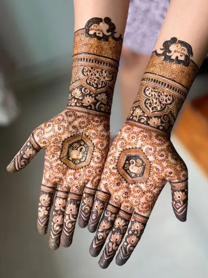 A lovely baby shower design featuring graceful swans in the palms and elephant motifs on the wrists.