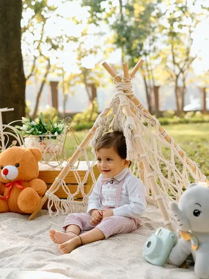 Another angle of our little picnicker, capturing his sweet expression as he enjoys the fresh air and his teddy bear companions.