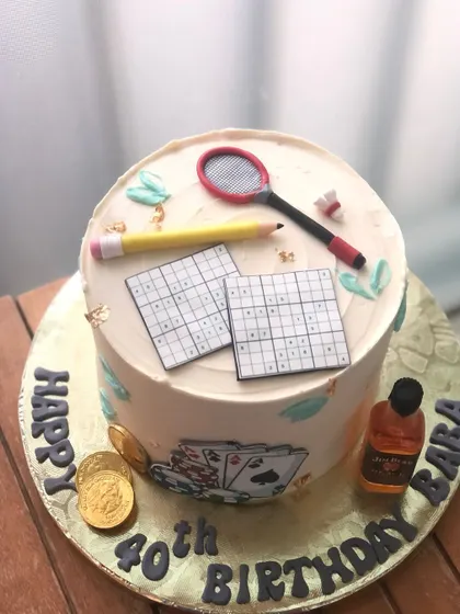 A fun 40th birthday cake that celebrates all of Dad's favorite hobbies, including Sudoku, badminton, and cards.