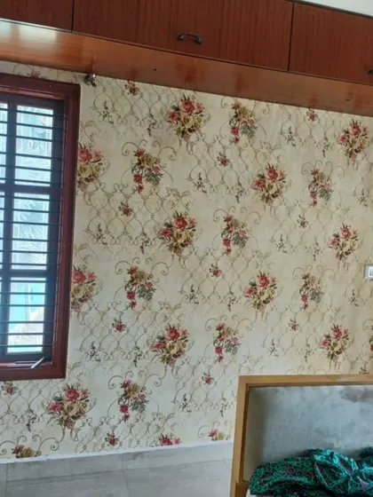 A traditional floral bouquet wallpaper in a bedroom. The classic design and warm colors create a cozy, country-style feel.