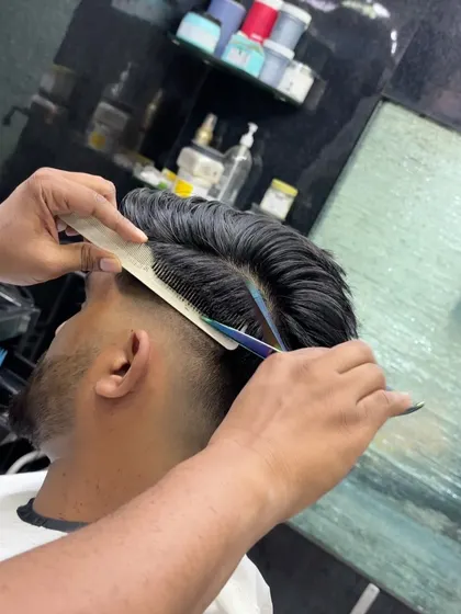 A close-up of the combing technique used to create a clean side part.