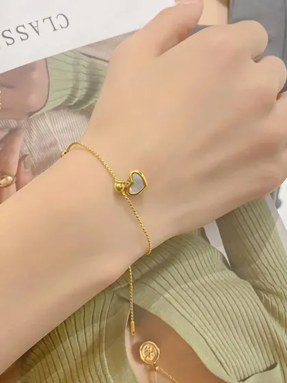 An adjustable slider bracelet with a mother-of-pearl heart charm. This piece is easy to wear and adds a touch of delicate beauty.