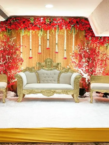 This reception stage at Acres Club's Crystal Hall is perfect for a large gathering. The decor is dominated by red flowers and traditional furniture, offering a classic and grand look for the celebration.