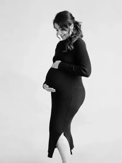 A simple yet powerful black and white silhouette. This artistic shot focuses on the beautiful curve of her baby bump, creating a timeless and iconic image of pregnancy.