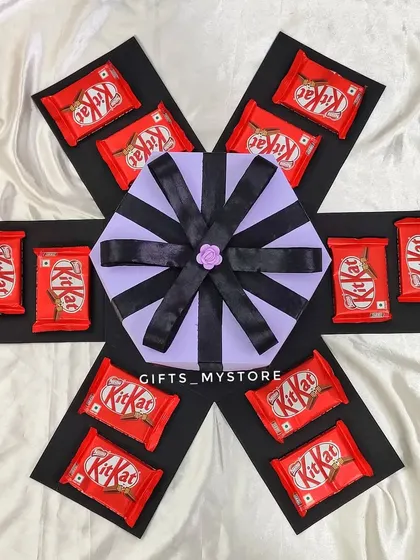 The first layer of a KitKat-themed butterfly explosion box, showing the neat arrangement of chocolates.