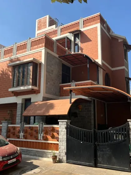 This home features a complex facade with multiple rooflines, bay windows, and a mix of stone and brick, creating a visually rich and dynamic exterior.