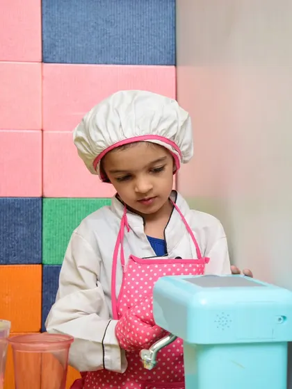 What's cooking? A little chef in her hat and apron is hard at work in our pretend play area.