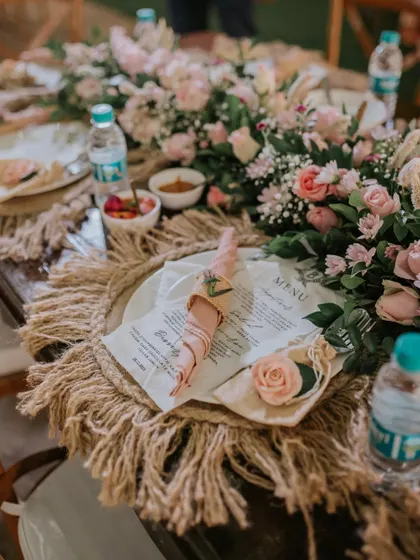 Every detail on the table is crafted to create a feeling of timeless romance. From the custom-printed menu to the delicate floral napkin rings, this setup invites guests to a truly special dining experience.