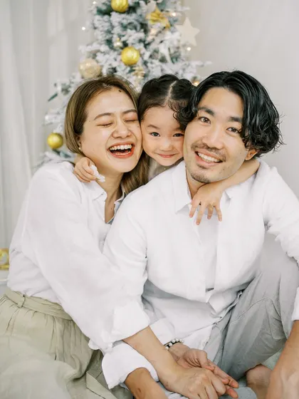 A happy family hug in front of the Christmas tree. The genuine joy and love are what make the holidays so special.