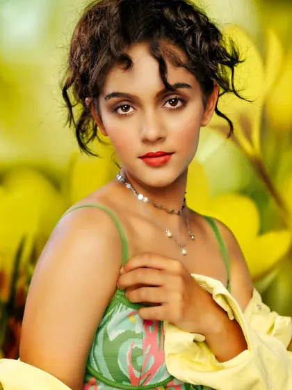 A fresh and vibrant portrait. The projected background of yellow flowers creates a cheerful and sunny atmosphere, while the soft lighting captures the model's innocent and engaging expression.