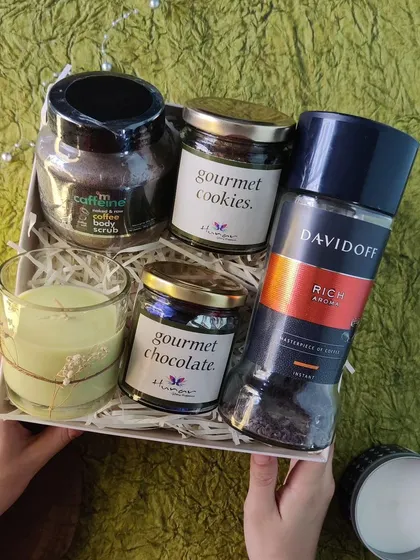 The 'Take It Easy' box is designed for ultimate relaxation. This self-care hamper includes Davidoff coffee, a coffee body scrub, gourmet treats, and a scented candle to help anyone unwind.