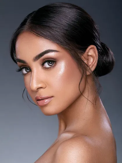 A classic soft glam look. The lighting creates a beautiful glow on the skin, and the simple updo and neutral makeup palette result in a portrait that is both elegant and approachable.