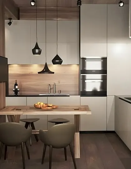 This compact kitchen cleverly incorporates a small dining table. The design uses a neutral palette and pendant lighting to create a cozy and functional eat-in kitchen in a small space.