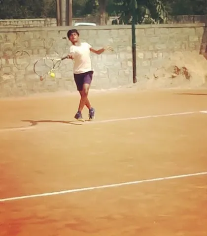 A young player mid-air while hitting a forehand during a UTR Tour match.