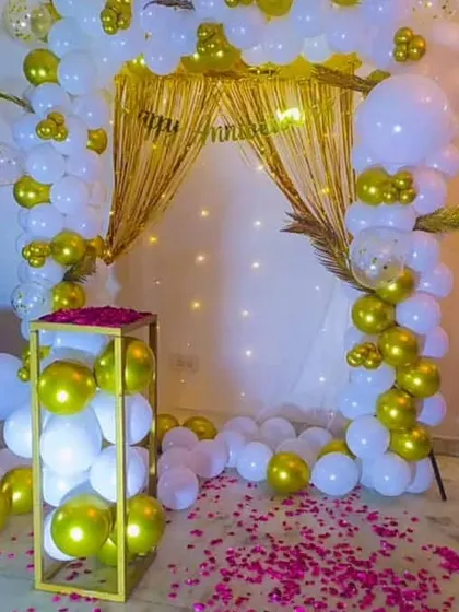 This image showcases the complete anniversary setup, combining the rose petal path with the shimmering gold and white backdrop.